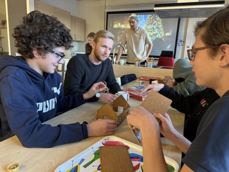 Niklas Blomquist och högstadieeleverna i Storfors kommun monterar pepparkakshus.